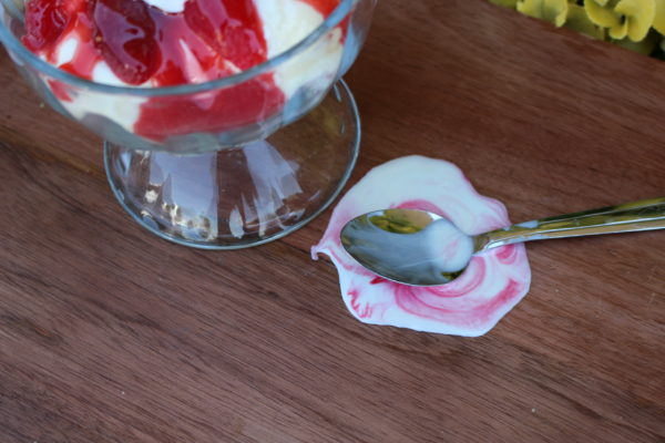SPOON IN MELTED ICE CREAM W STRAWBERRY CU